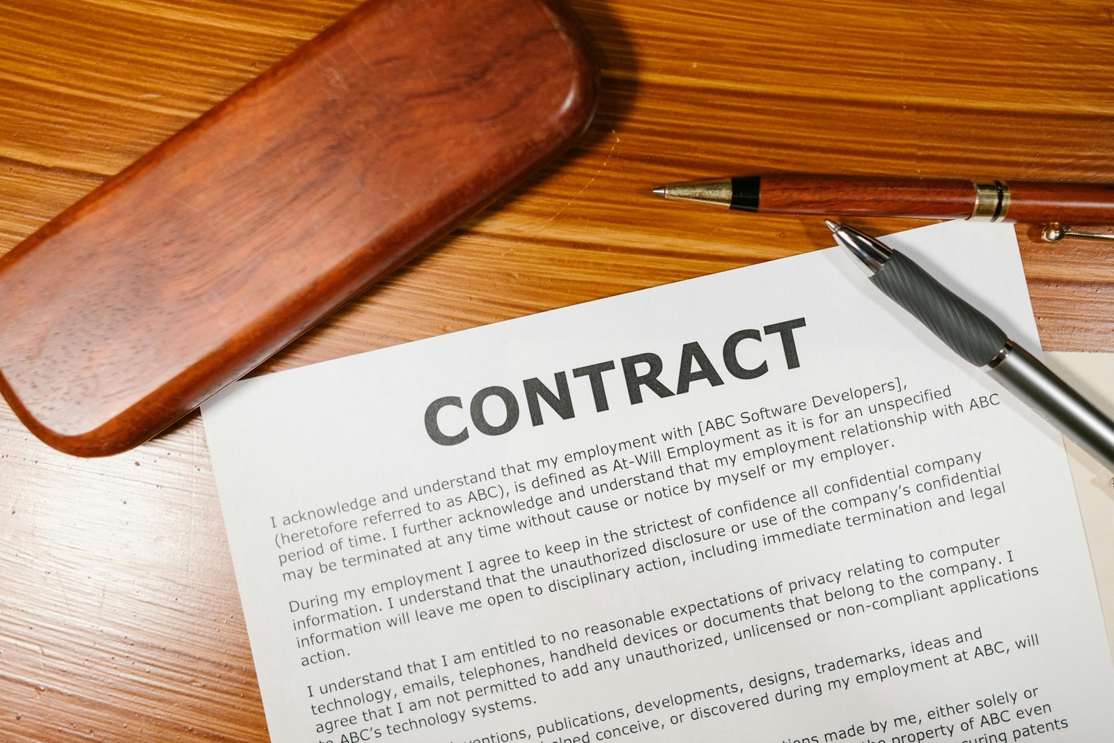 Reviewing and signing contract — Photo by RDNE Stock project: https://www.pexels.com/photo/a-contract-on-brown-wooden-surface-7841411/